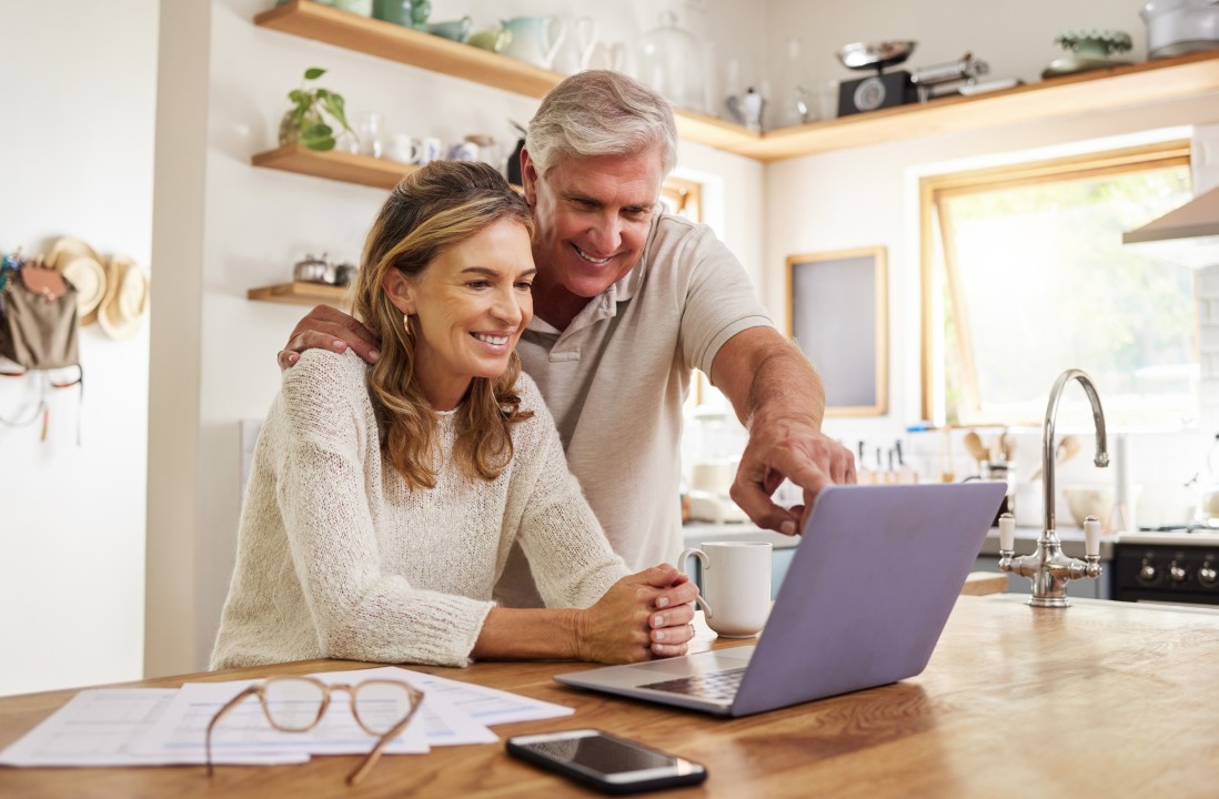 Happy couple looking at laptop together